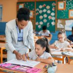 black-elementary-school-teacher-assisting-her-stud-2023-11-27-05-23-35-utc